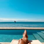 man relaxing by the pool overlooking the ocean
