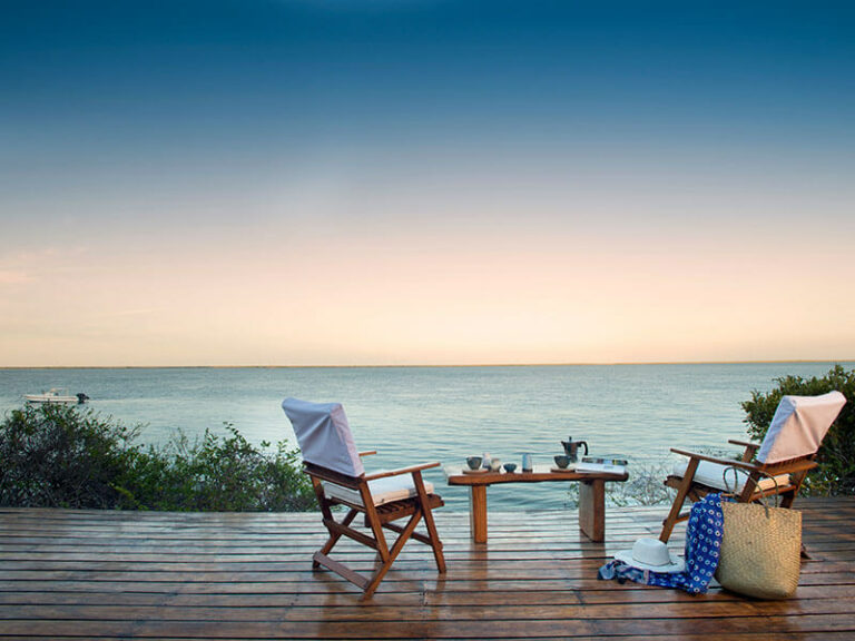 Outdoor patio with table and chairs overlooking the ocean