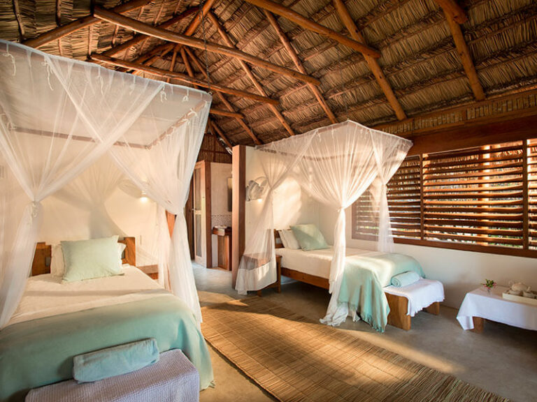 White beds and linen in the bedroom of Rio Azul Lodge