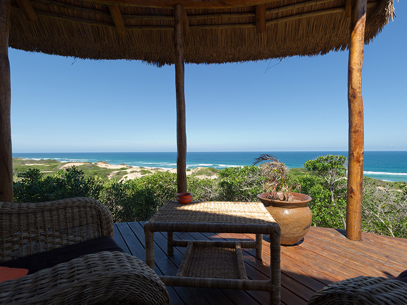 outside paito with table and chairs overlooking the ocean in Dunes de Dovela Eco Lodge