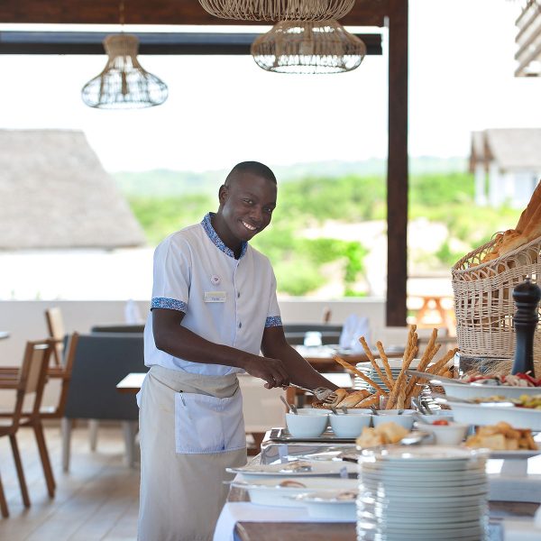 A waiter serving the table at diamonds mequfi resort