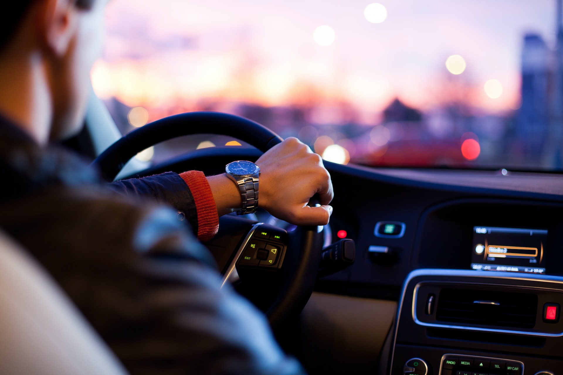 A man wearing a watch driving his car