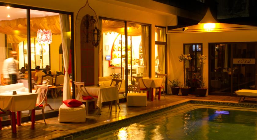 Outside patio with pool in the evening at Villa das Arabias Boutique Hotel in Maputo