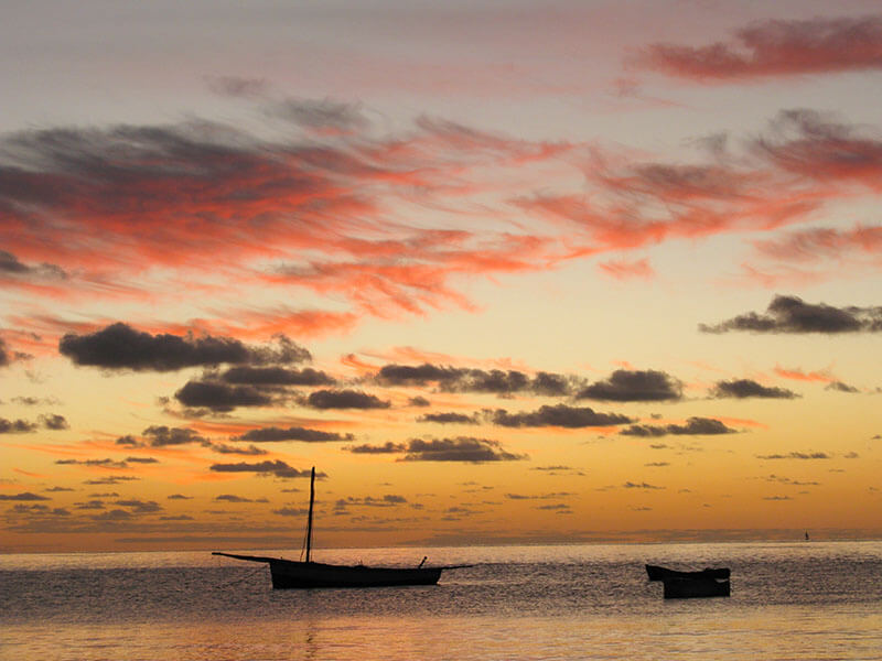 two dhows sitting in the ocean of Mozambique during sunset