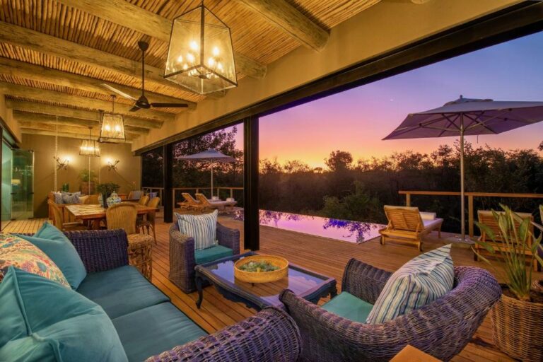 Lounge interior with pool and deck in the back outside at Royal Malewane Lodge