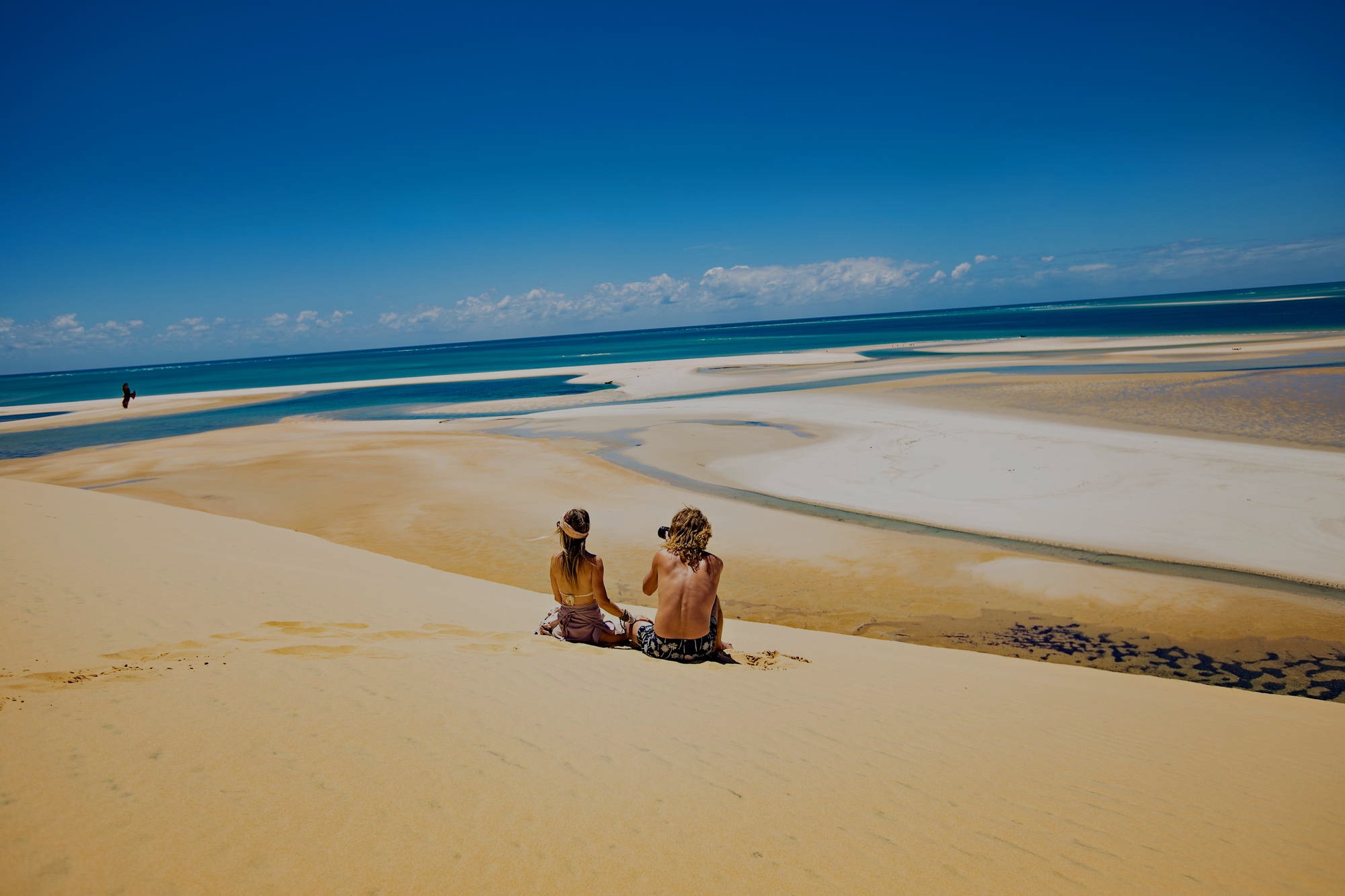 A couple looking over the Bazaruto in Mozambique from the dunes