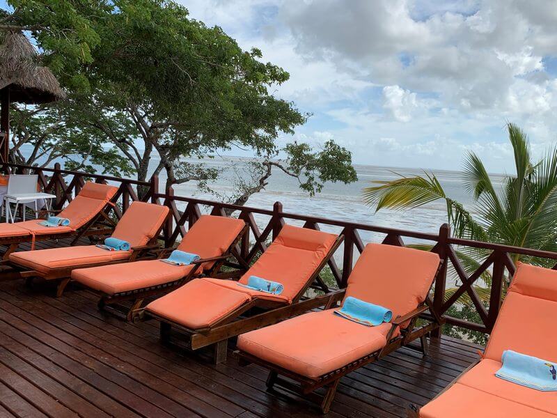 six sunbeds lined in a row overlooking the ocean at Moyeni Lodge in Mozambique