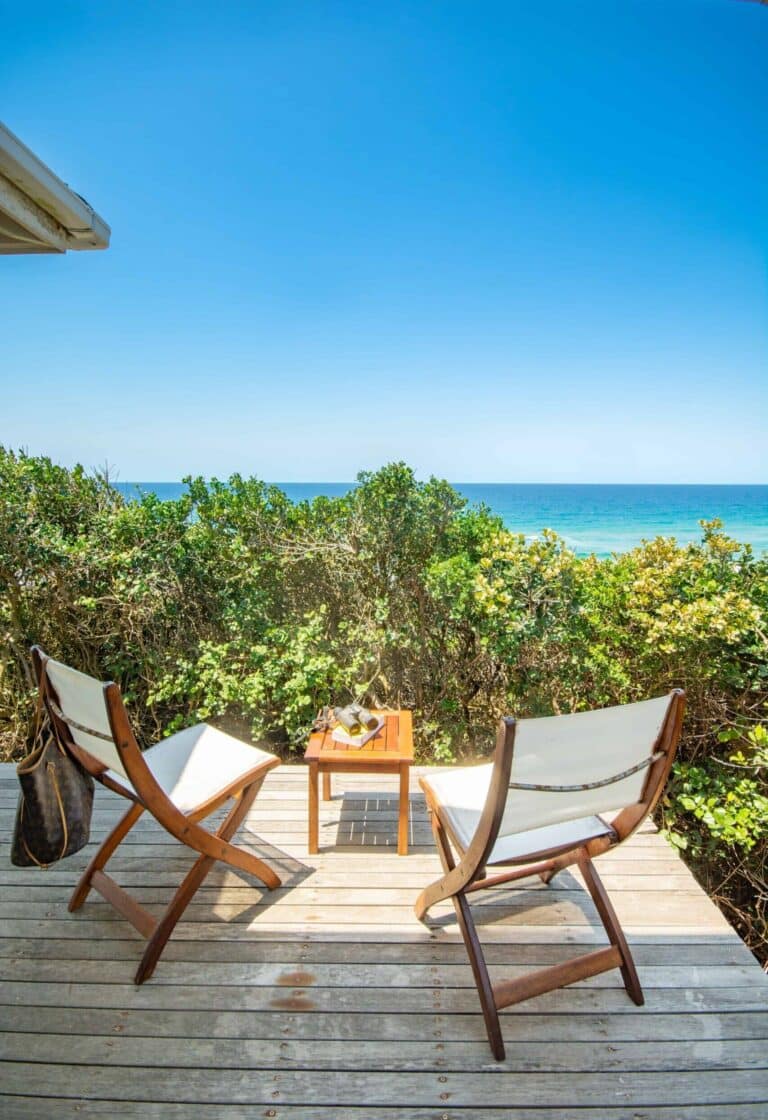 outside wooden patio with two chairs and a small table overlooking the ocean in Mozambique