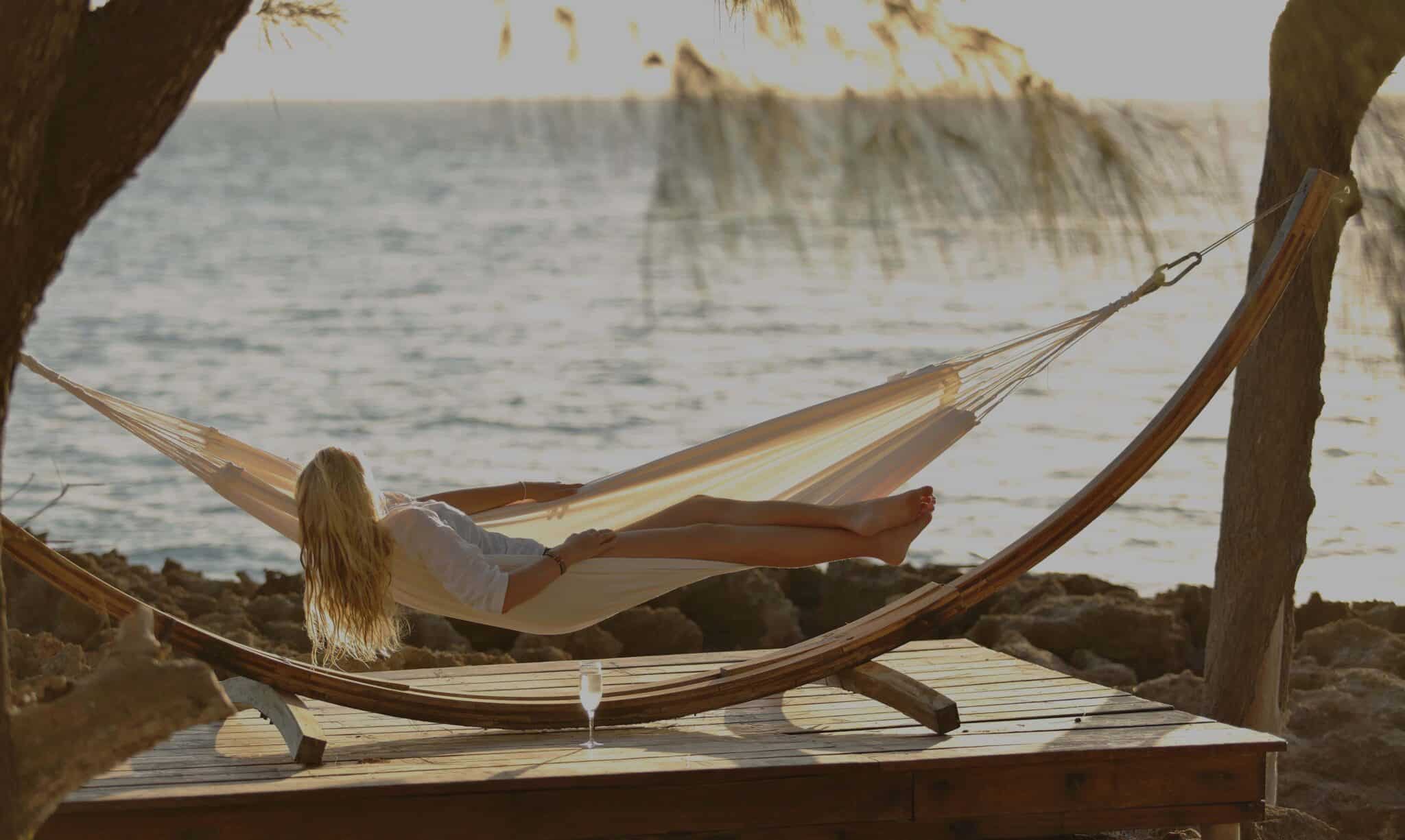 woman relaxing on hammock overlooking the ocean while there is some good weather for Mozambique