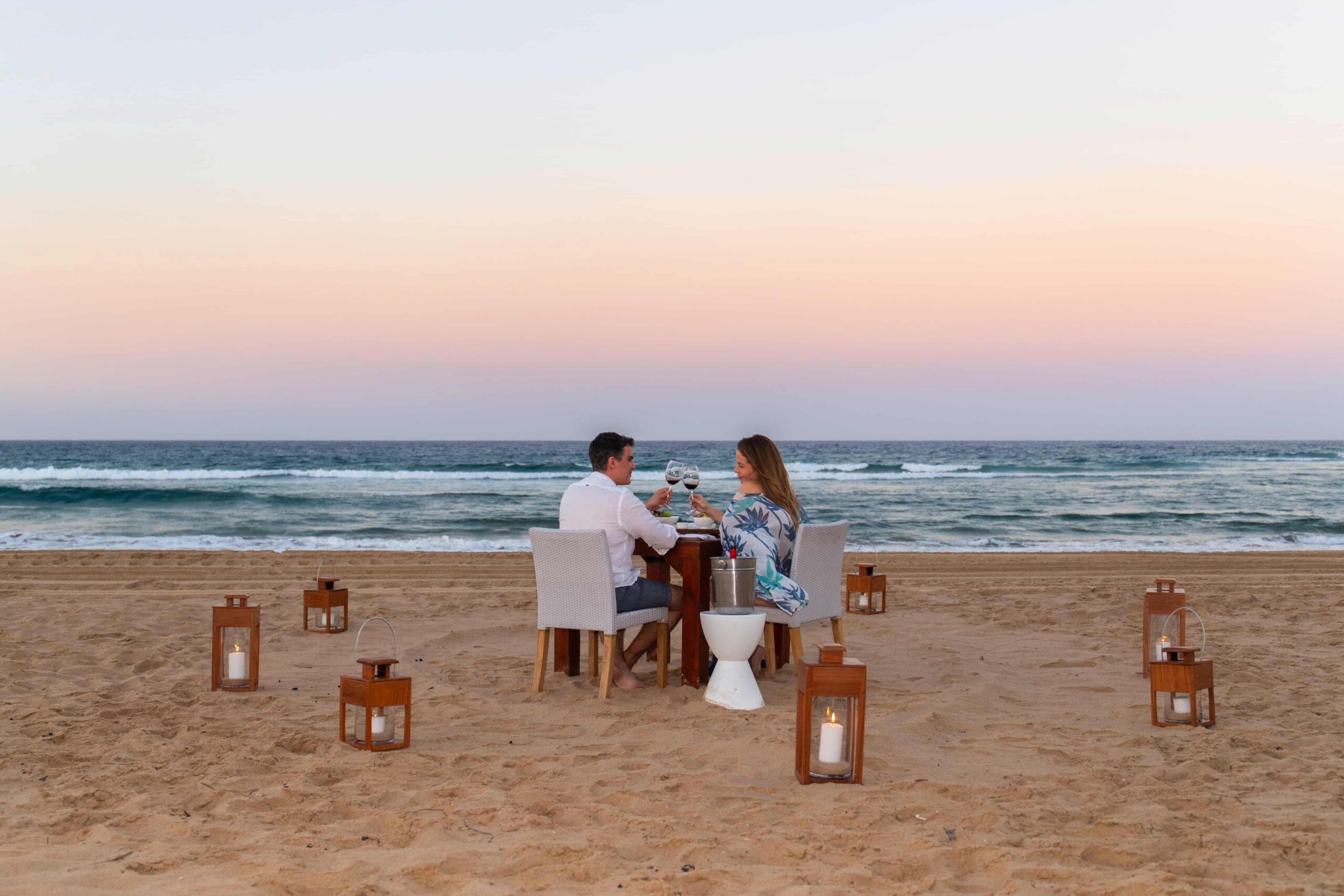 A couple having a romantic sunset dinner on the beach